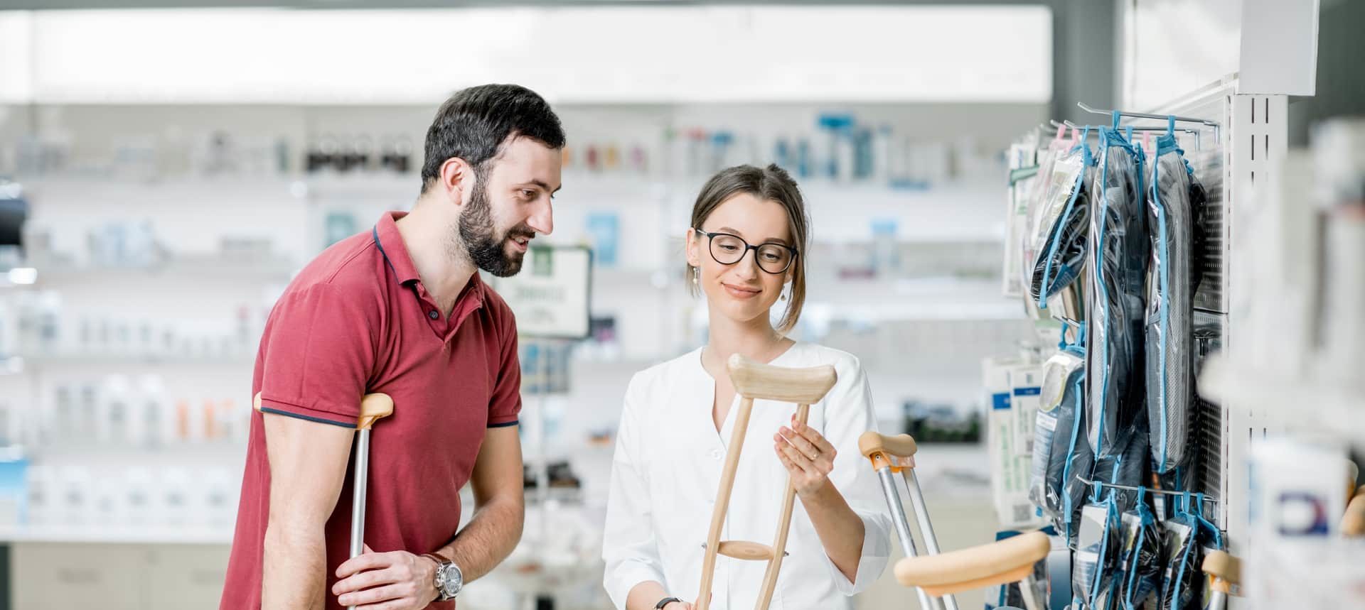 a couple is looking at crutches in a medical products store