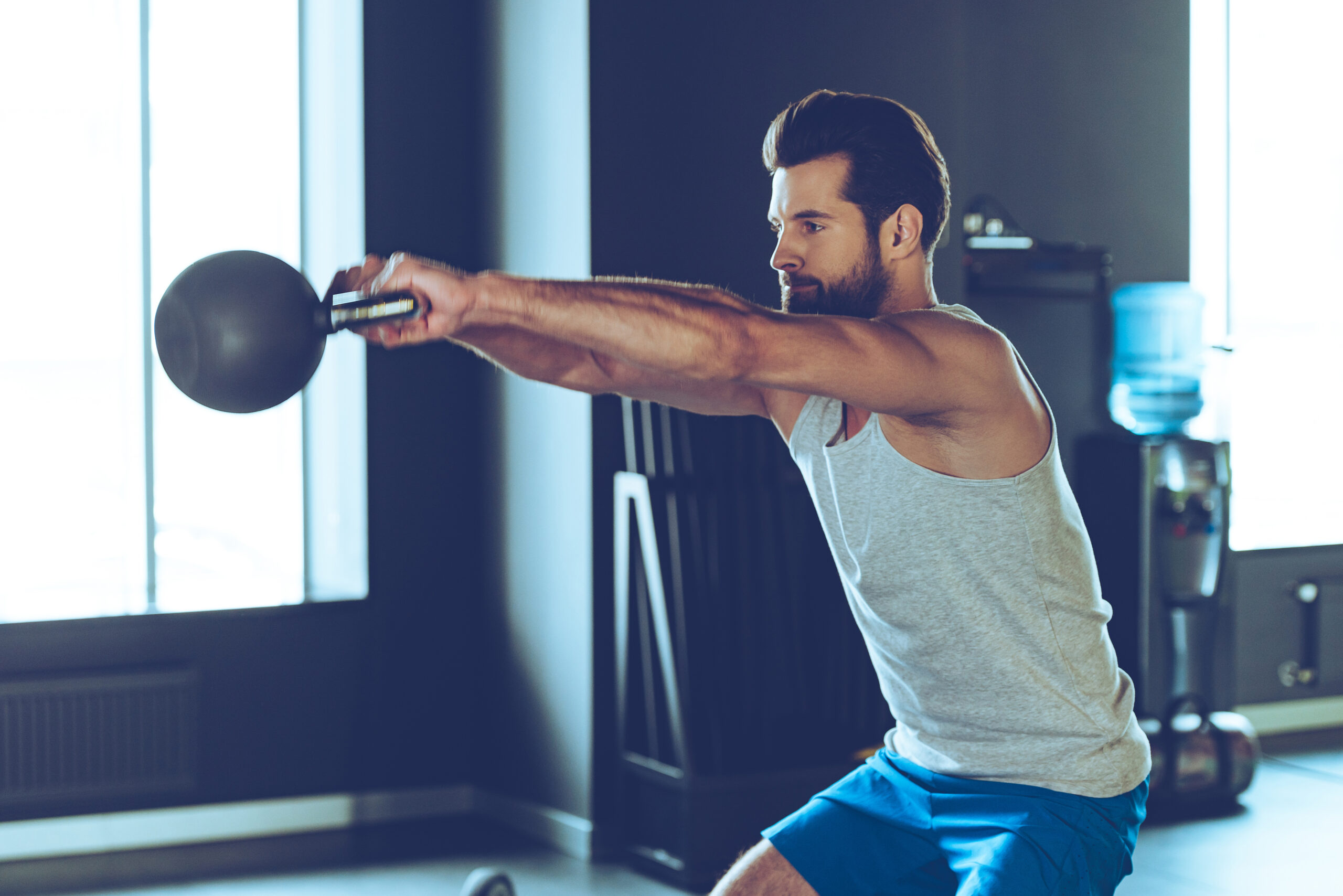 Man doing a kettlebell workout to support men’s health and exercise benefits.
