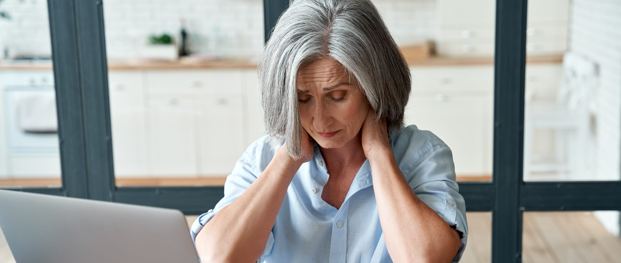 Woman rubs painful neck