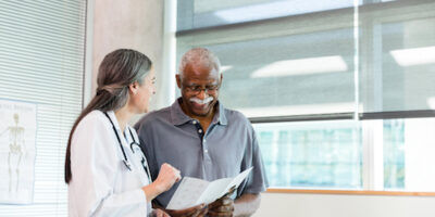 Physician talking with man about his results.