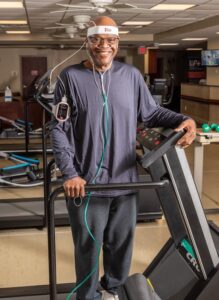 Pulmonary Rehab patient smiling and standing on treadmill. 