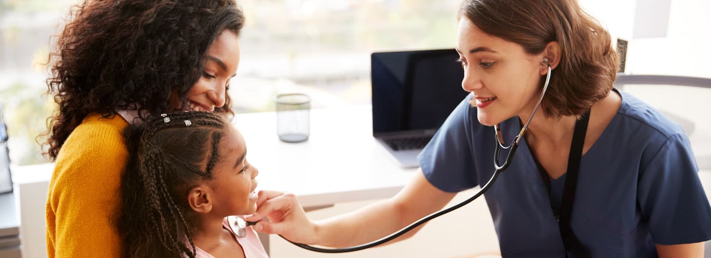 Doctor listens to child's heart.