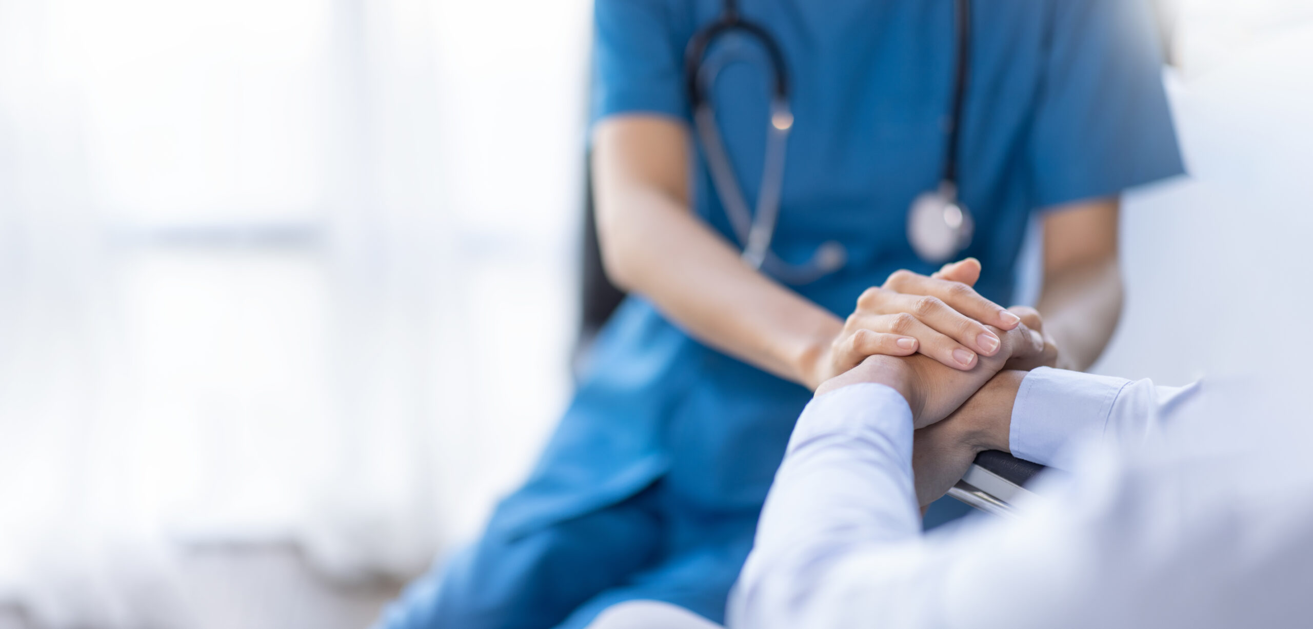 Nurse holding an elderly patient's hand