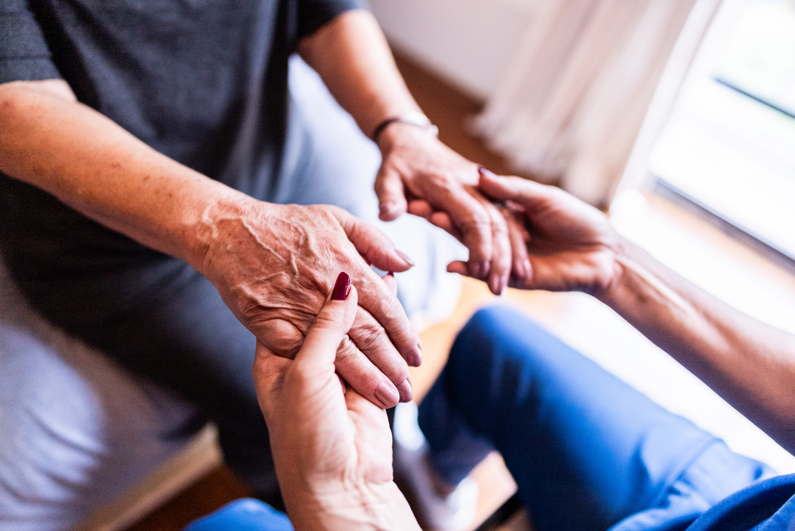 Nurse holding hands with parkinson's patient